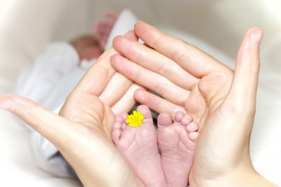 抱着婴儿脚趾的人，中间有黄色花瓣的花